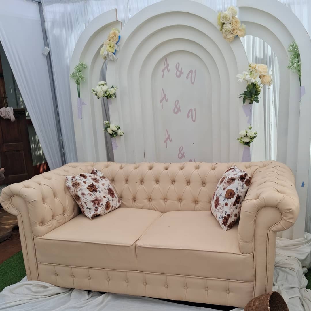 Chesterfield sofa with arched floral backdrop for a wedding