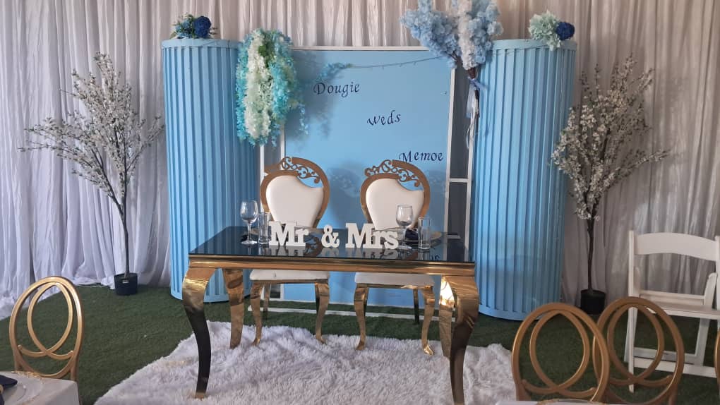 Mr and Mrs wedding head table with blue backdrop and gold furniture
